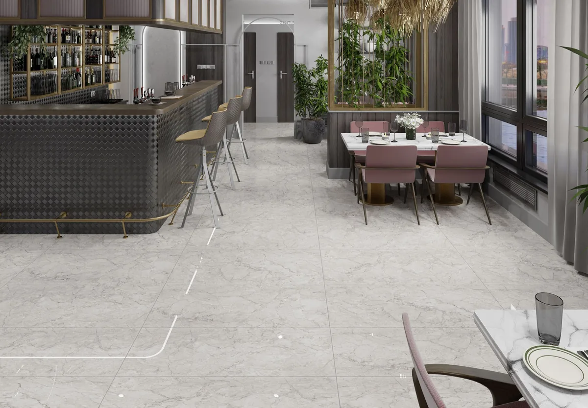 Ambiente de restaurante con piso claro veteado, barra oscura y mesas junto a ventanales.