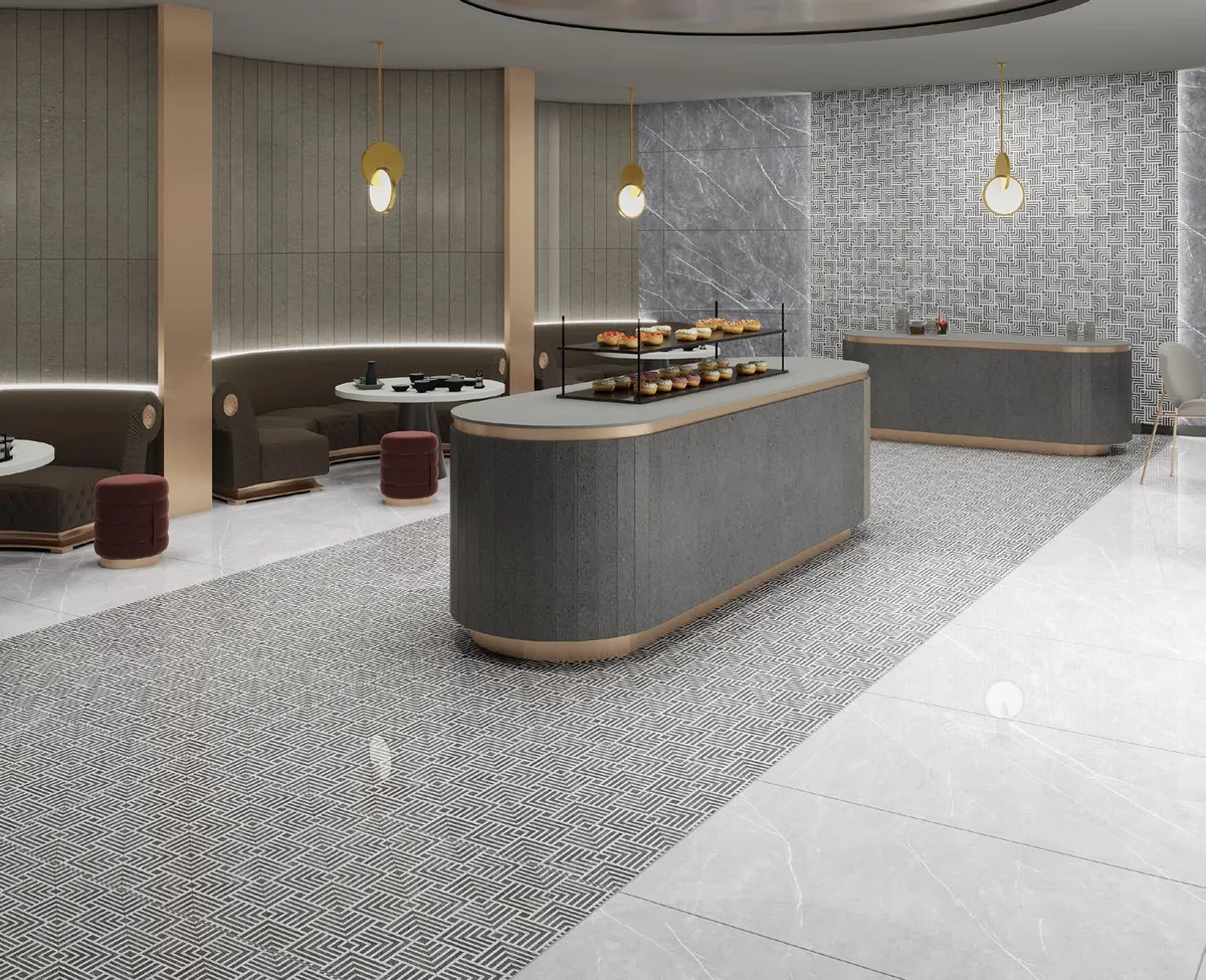 Ambiente comercial con piso geométrico gris y mostradores oscuros.